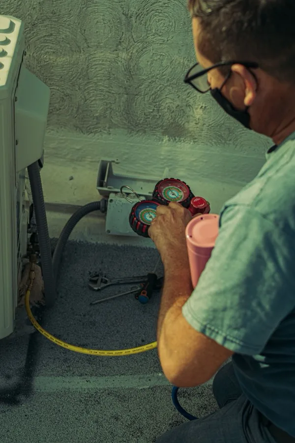 Bucca Fix technician using manifold gauges to service an HVAC unit